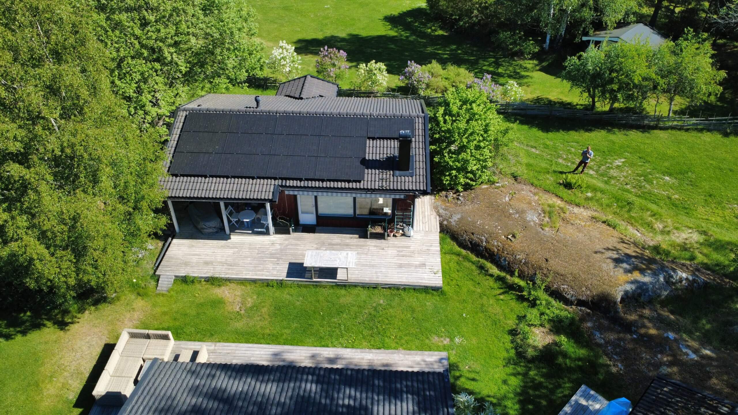 Solcellsanläggning med ödrift på Värmdö En skräddarsydd solcellsanläggning med svarta paneler monterad på ett villatak på Värmdö, fotograferad med drönare.