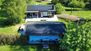 Flygfoto över en solcellsanläggning på Värmdö där två olika takytor har maximerats med olika panelstorlekar för högsta möjliga effekt.