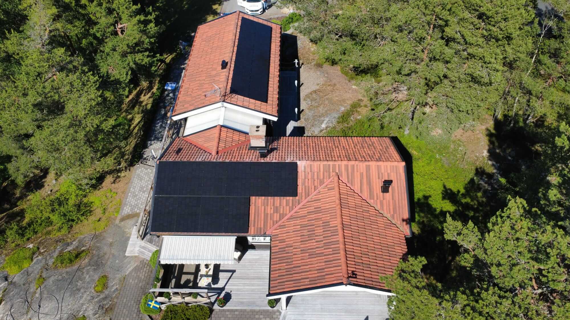 Översiktsbild av solcellsanläggningen på Ingarö Flygfoto som visar hela fastigheten på Ingarö med solpaneler installerade på två olika takvinklar.