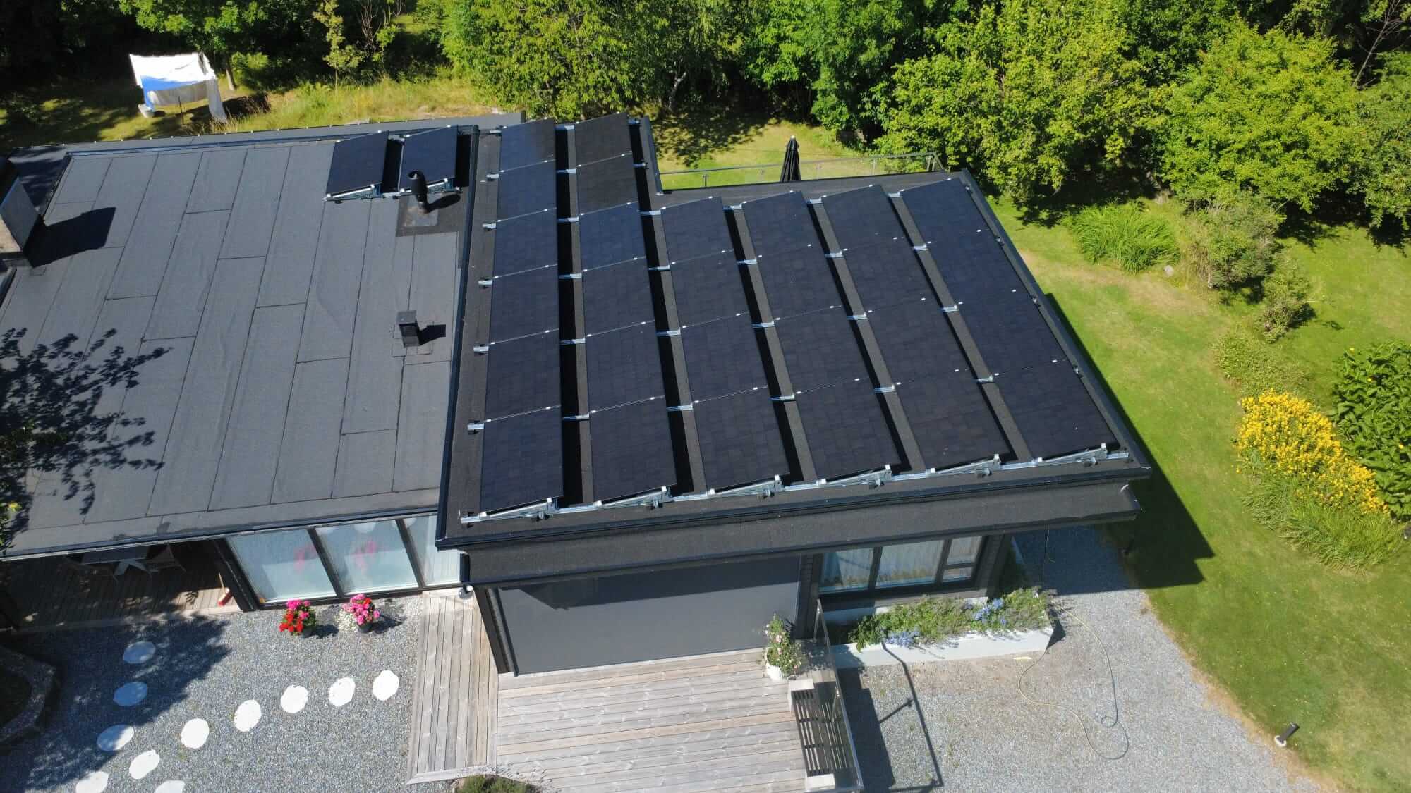 Solpaneler uppvinklade med montagesystem i 15 grader mot söder för att maximera elproduktionen på ett papptak.
