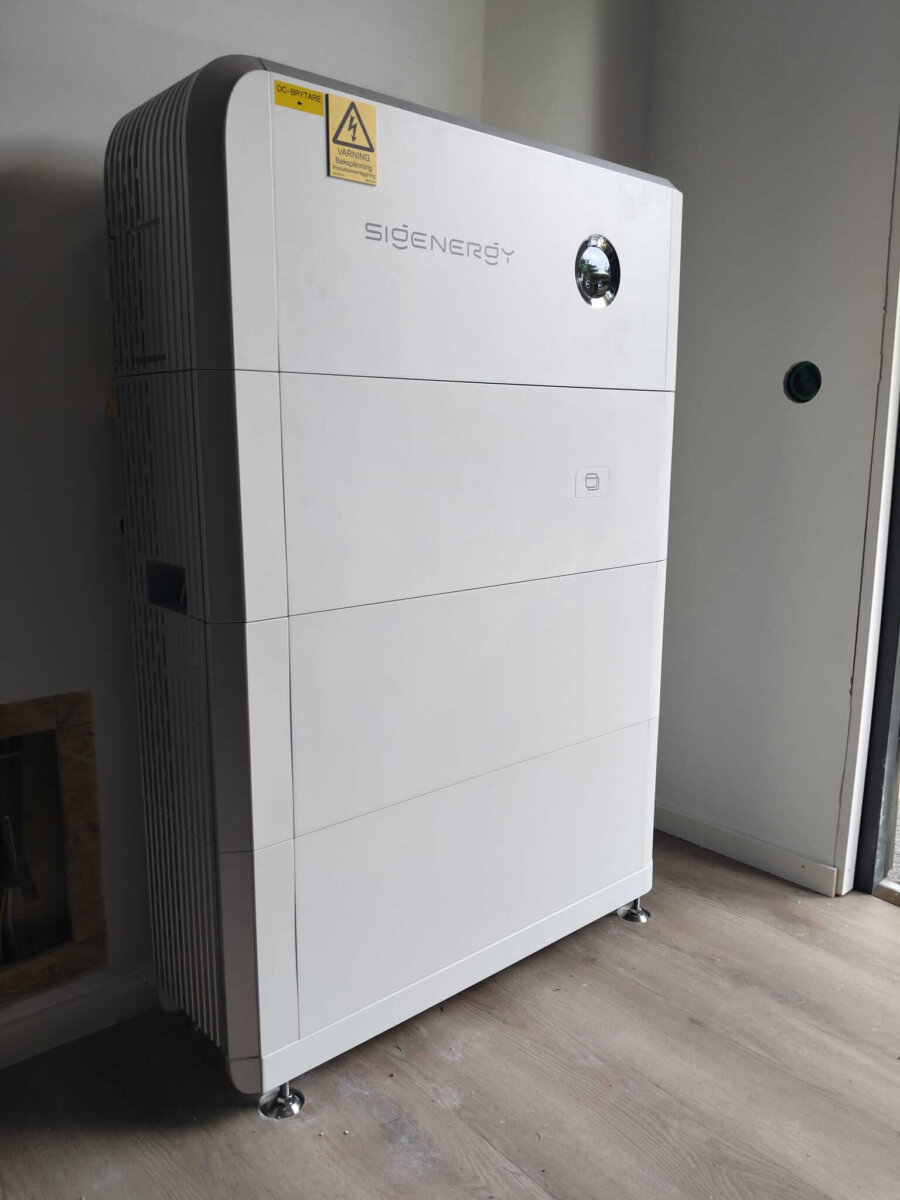 Vit Sigenergy-anläggning med 18 kWh batterilagring och integrerad DC-elbilsladdare installerad inomhus på Värmdö.